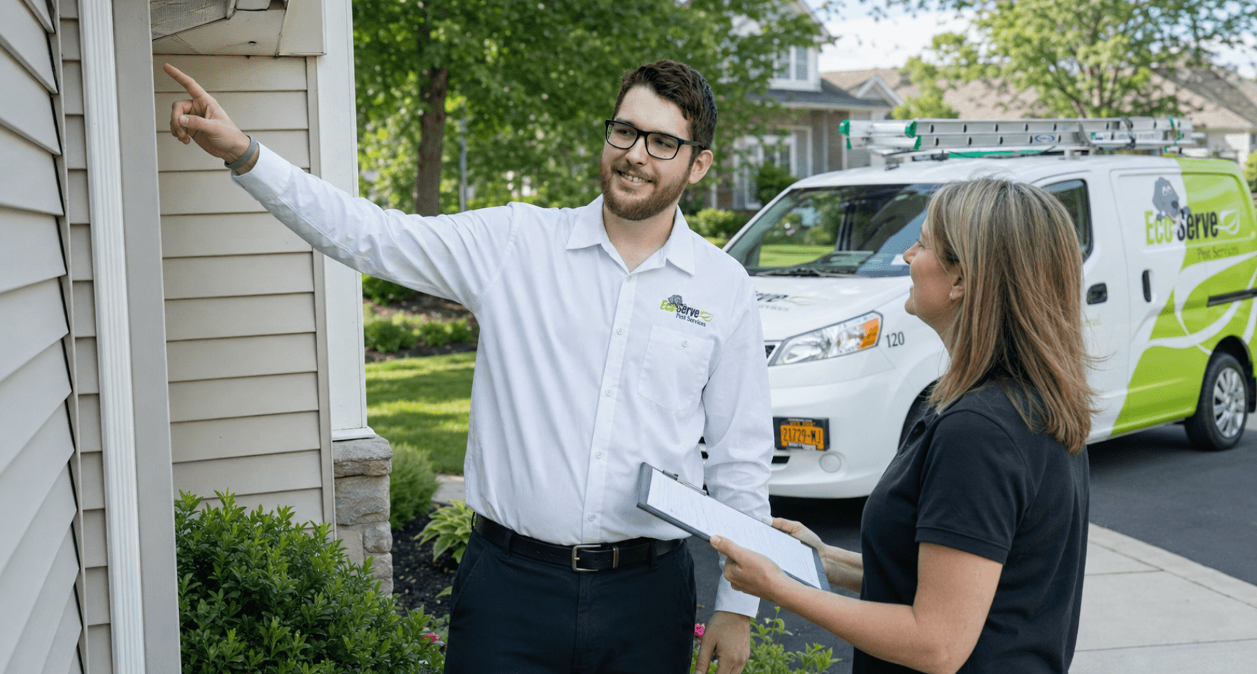 An Eco Serve service specialist inspects a potential yellow jacket nesting area and discusses treatment options with a homeowner