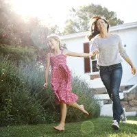 mother and daughter running outside of their new york home