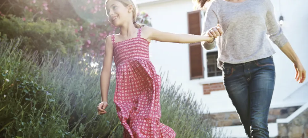 mother and daughter running outside of their new york home